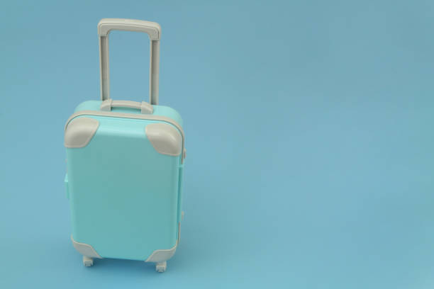 istock Travel suitcase or bag on blue background with copy space for text. 1414990208