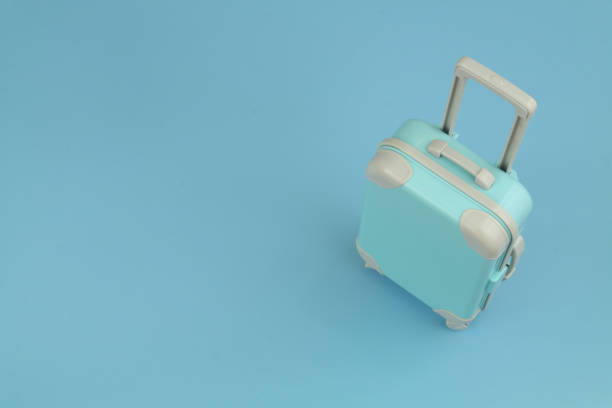 istock Travel suitcase or bag on blue background with copy space for text. 1414990298