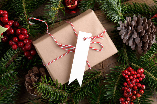 istock Christmas rectangle strip gift tag mockup with present box, product label mockup, with natural fir tree branch, name tag 1414990495