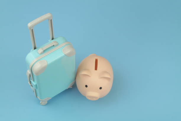 istock Piggy bank and blue suitcase on blue background. 1414991083