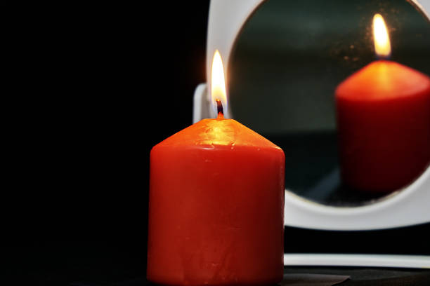 istock burning red candle with reflection in the mirror on a black background in Gothic style 1414991233