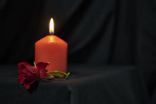 istock a red burning candle and a red rose on a black background copy space gothic style 1414991338