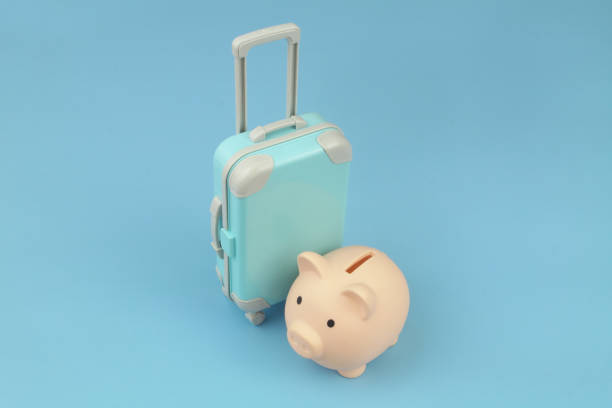 istock Piggy bank and blue suitcase on blue background. 1414991370