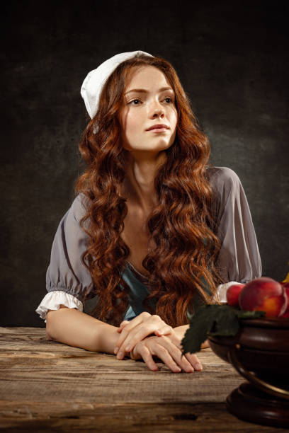 retrato vintage da jovem e adorável garota ruiva em imagem de pessoa medieval em estilo renascentista vestido isolado em fundo escuro. comparação de épocas - princess women duchesses renaissance - fotografias e filmes do acervo