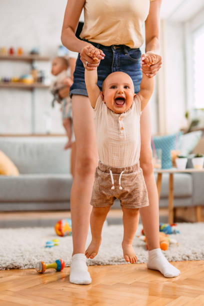 istock Young Mother Teaching Her Baby How To Walk 1414993316