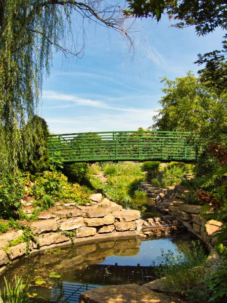 istock Green Bridge Crossing Beautiful Flower Garden 1414994907
