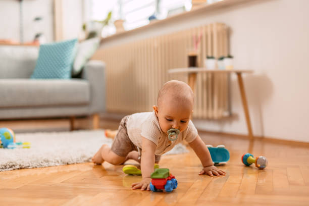 istock Newborn Baby Boy Playing On The Floor 1414995096