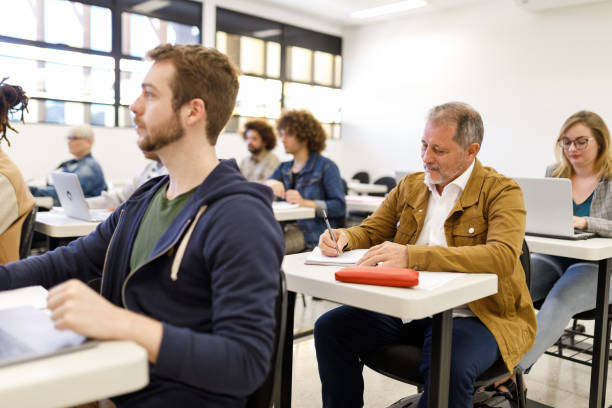 Older student taking notes during class going back to school mature student stock pictures, royalty-free photos & images