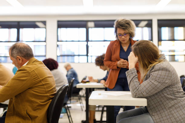 istock Professor answering a student's doubt during the exam 1414996917