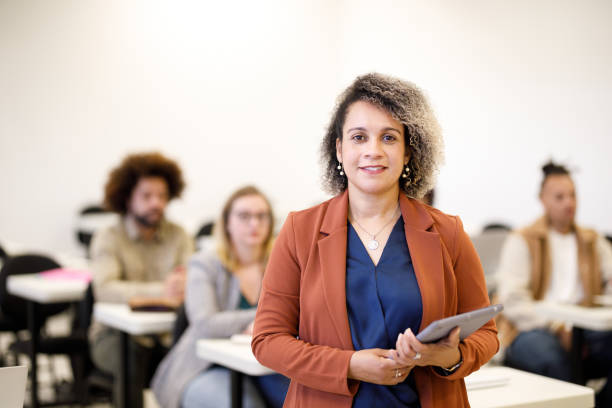 University professor holding a tablet in front of class going back to school professor stock pictures, royalty-free photos & images