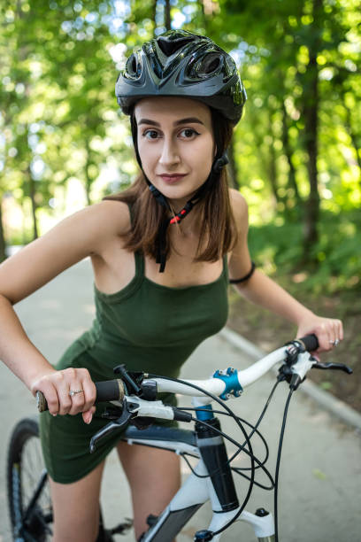 istock Pretty young slim woman on a bicycle rest after activity in the forest 1414997674