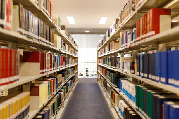 corridoio con scaffali pieni presso la biblioteca - book library bookshelf university foto e immagini stock