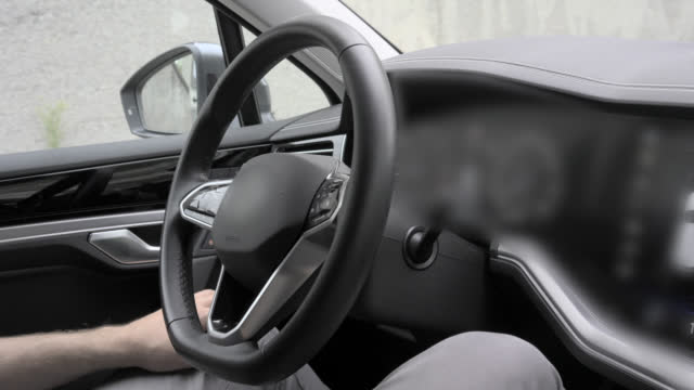 Self driving car turns the steering wheel while automatically parking in reverse gear without the driver's assistance.