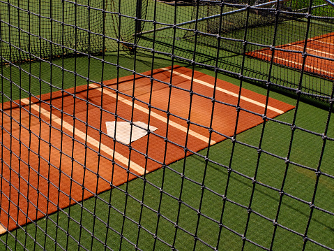 Baseball practice area fence with home plate for warm up pitching