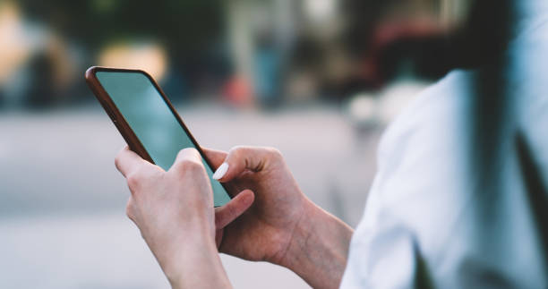 istock Unrecognizable woman surfing cellphone in park 1415001877