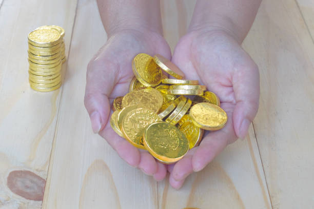 istock Golden coins money  in hand on background. 1415003213