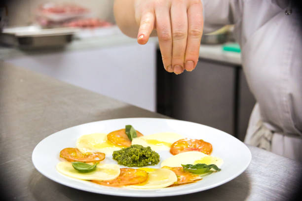 istock Female hand salting tomato salt 1415003927