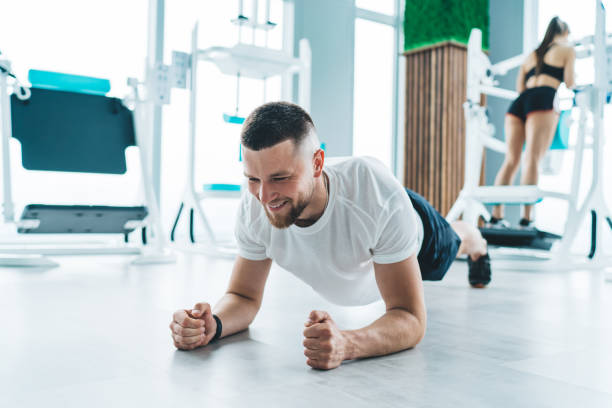 istock Sportsman doing plank on elbows in gym 1415006295