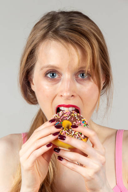 istock Woman eating donut 1415007241