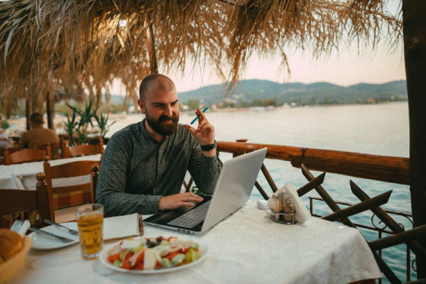 istock Man using a laptop and having an online class at the summer vacation 1415008185