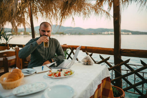 istock Man using a laptop and having an online class at the summer vacation 1415008302