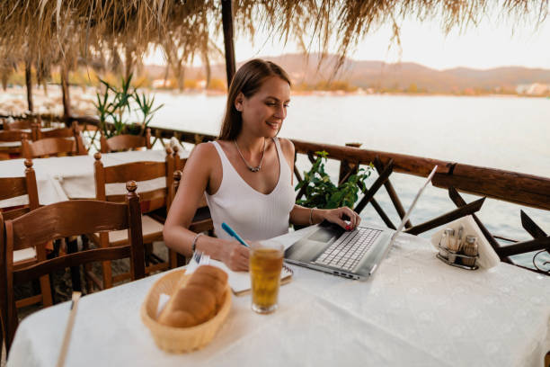 istock Woman studying and doing homework during seaside vacation 1415008431