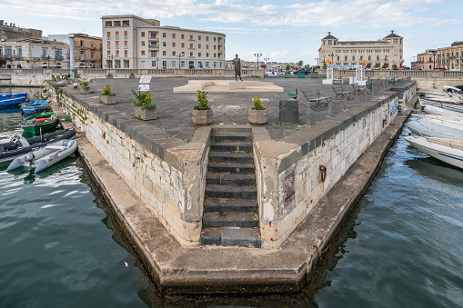 A view of the harbour in Syracuse. In the background is a monument to Archimedes