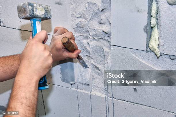 Construction Worker Gouges Niche In Concrete Wall Using Hammer And Chisel Stock Photo - Download Image Now