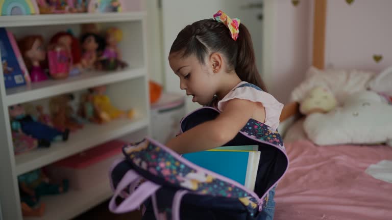 Girl preparing backpack in the bedroom