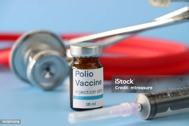 Closeup Image Of Polio Vaccine Labelled Glass Vial Besides A Syringe And Stethoscope Blue Background Focus On Foreground Copy Space Stock Photo - Download Image Now