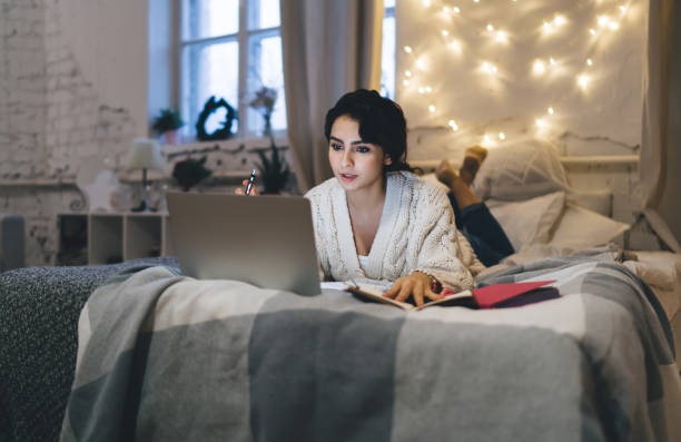 istock Pensive woman with laptop on bed 1415014741