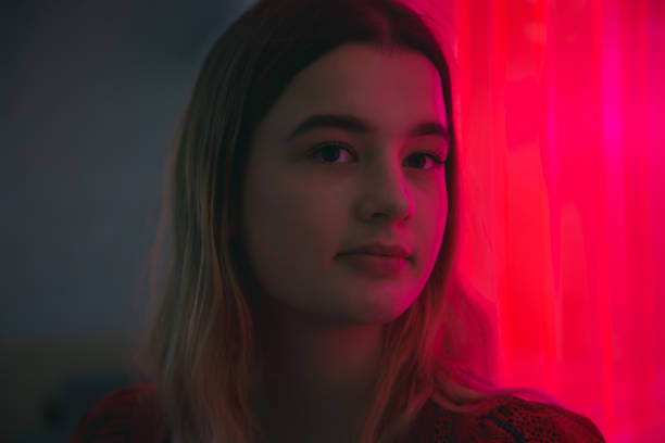 istock Close up, young woman's face in neon red light. 1415019839