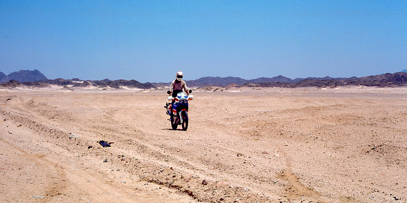 Eastern desert, Egypt - aug 15, 1991: along the track towards Safaga, a motorcyclist tackles the difficult sandy and stony track that crosses the eastern Egyptian desert.