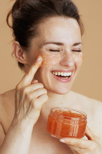 smiling modern 40 years old woman with face scrub
