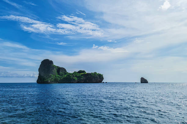 magnifique point de repère de montagne rocheuse de l’île et paix de l’eau de mer de l’océan en thaïlande avec un paysage de fond de ciel bleu nuage - vibrant color summer rock cliff photos et images de collection