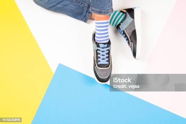 Kid Wearing Different Pair Of Socks Child Foots In Mismatched Socks And Colorful Sneakers Sitting On White Background Top View Odd Socks Day Antibullying Week Down Syndrome Awareness Concept Stock Photo - Download Image Now