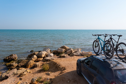 Two bikes on the roof rack of a car against a beautiful nature. Bike transportation on car