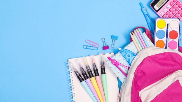istock School backpack with stationery and writing tools on pastel blue background. Flat lay copy space 1415027499