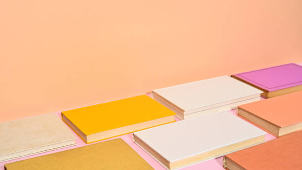 istock Pastel colored vinate hardcover books on pastel pink and orange background. Copy space pattern flat lay 1415028864
