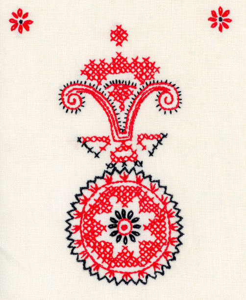 Red and black cross stitch embroidery motif on linen.