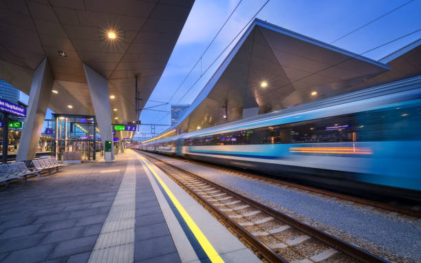 istock High speed train in motion on the railway station at night. Moving blue modern intercity passenger train, railway platform, architecture, city lights. Modern train station in Vienna, Austria. Railroad 1415031451