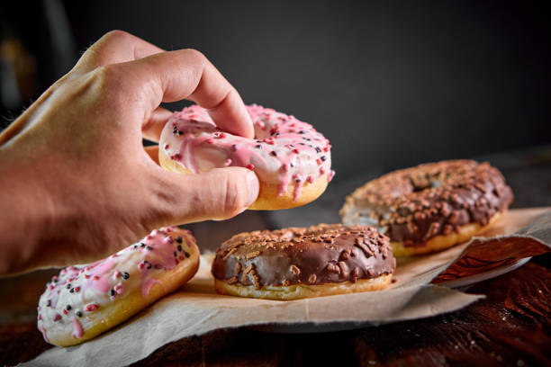 istock hand takes sugar sweet donut 1415035727