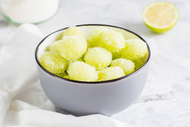 Sour candy grapes in a bowl, lime and sugar for cooking. Social media candy trend. Close-up Sour candy grapes in a bowl, lime and sugar for cooking on the table. Social media candy trend. Close-up frozen grapes stock pictures, royalty-free photos & images