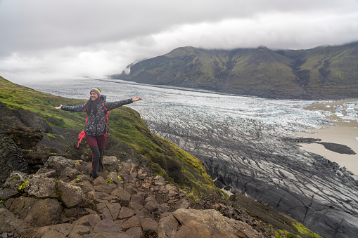 Rear view of women standing on rock at Skaftafell Glacier in Vatnajokull National Park, South Iceland