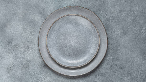 istock Empty gray plates on a gray stone background. Dishes for table setting. Top view, flat lay. Banner 1415046543