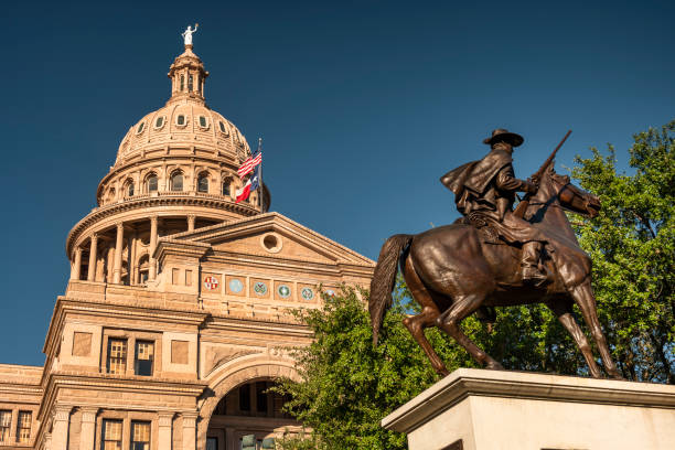Pedestrians and traffic drive down Congress Avenue by the Texas State Capitol building in Austin stock photo