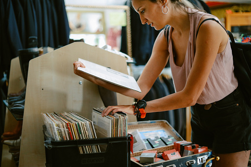 Woman is browsing through the vinyl records in the vintage music shop in Berlin.