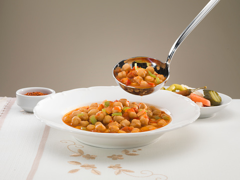 Chickpeas in tomato sauce in bowl closeup.