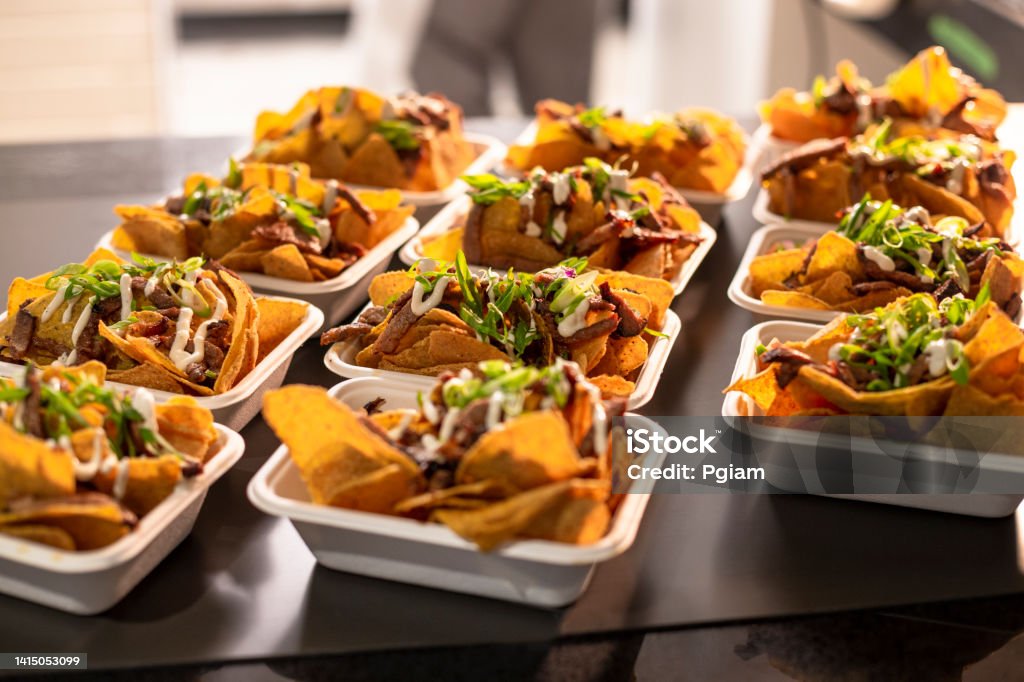 Bar appetizer nacho take out food on a counter Restaurant appetizer nachos and BBQ beef take out food on a restaurant counter Barbecue - Meal Stock Photo