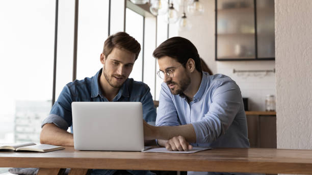 istock Startup partners discussing project at laptop, watching video presentation 1415053177